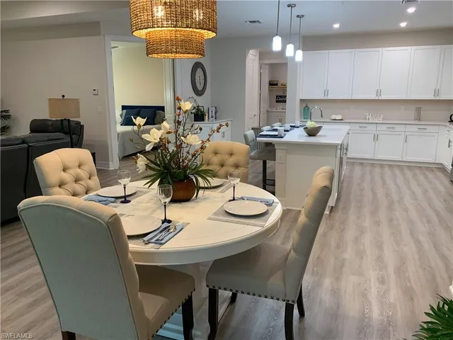 a kitchen with a dining table chairs and white cabinets