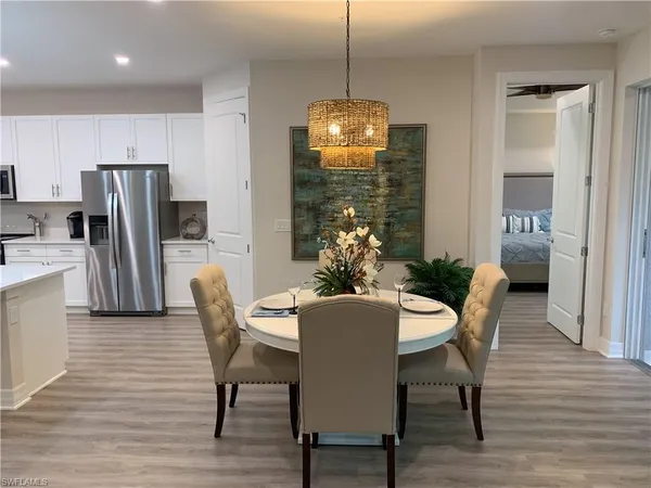 a dining room with furniture a chandelier and wooden floor