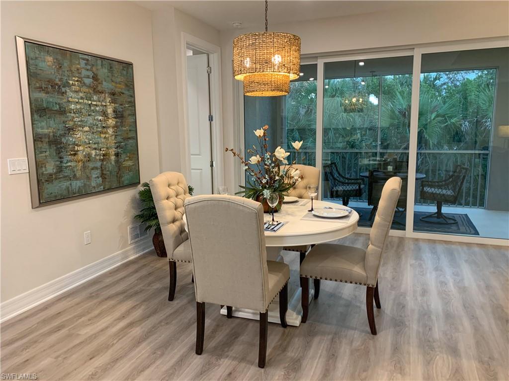 208 Indies Drive East, Unit 202 Naples, FL 34114 - Photo 10 of 48 a dining room with furniture wooden floor and a chandelier