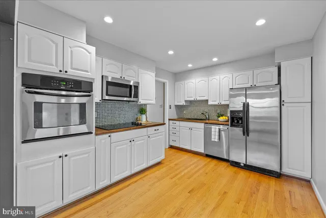 a kitchen with granite countertop a refrigerator stove top oven and sink