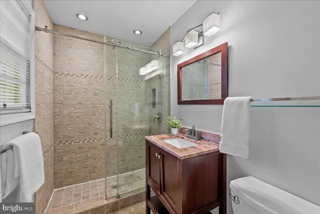 a bathroom with a sink a toilet and shower