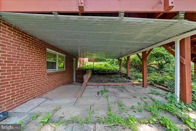 a backyard of a house with fountain plants and large tree