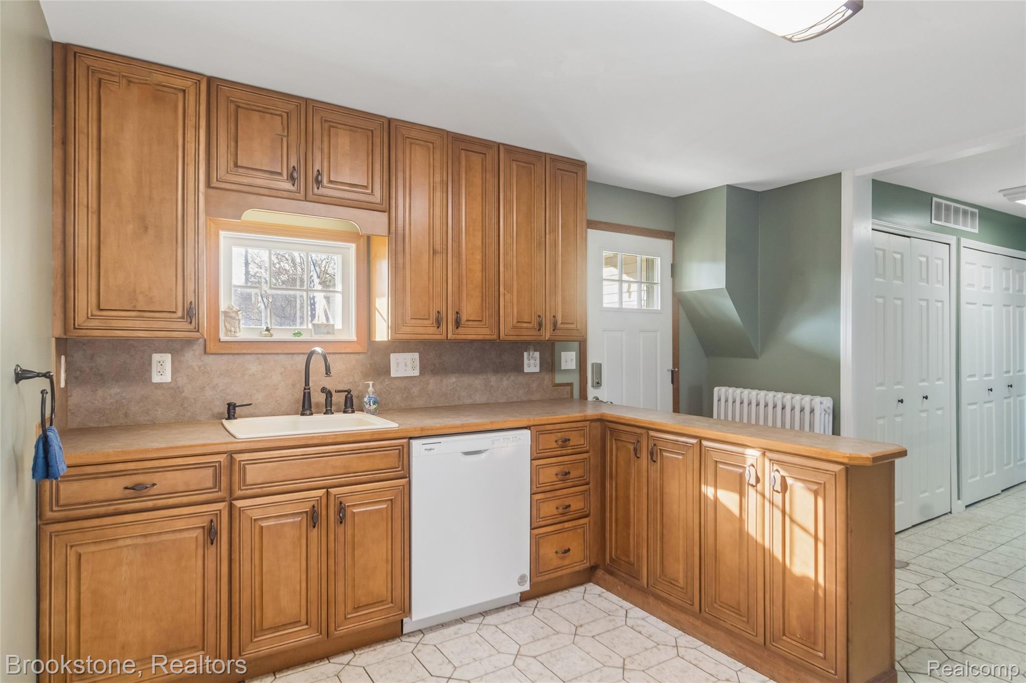 2230 Elm Street Algonac, MI 48001 - Photo 24 of 59 Kitchen with light countertops, a peninsula, wood finish cabinetry, dishwasher, and tasteful backsplash