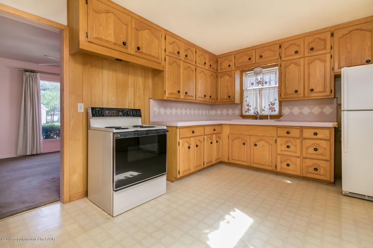 4117 South Travis Street Amarillo, TX 79110 - Photo 5 of 12 a kitchen with granite countertop a stove a sink and a refrigerator