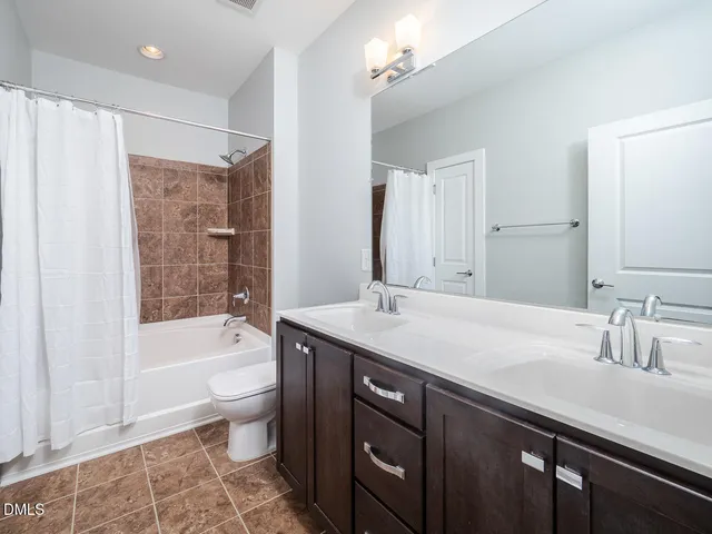 a bathroom with a tub a sink and a large mirror