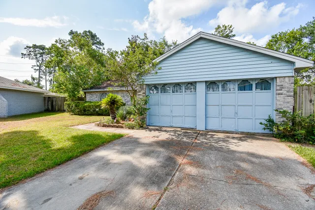a front view of a house with a garden and garage