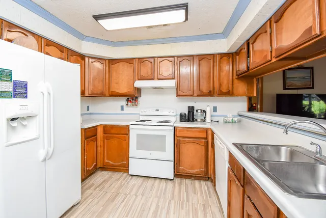 a kitchen with stainless steel appliances granite countertop a sink a stove and refrigerator