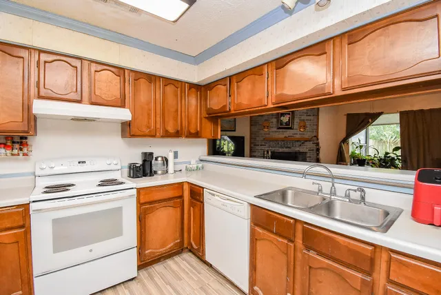 a kitchen with granite countertop a sink stainless steel appliances and cabinets