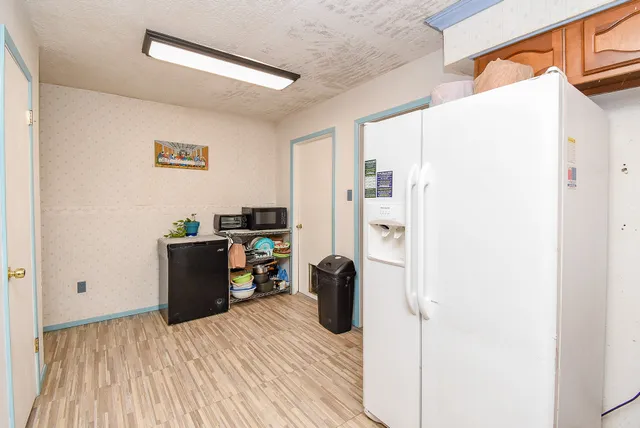 a room with a refrigerator and a dresser