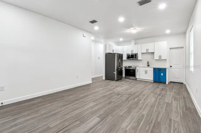 a view of kitchen and stainless steel appliances with wooden floor
