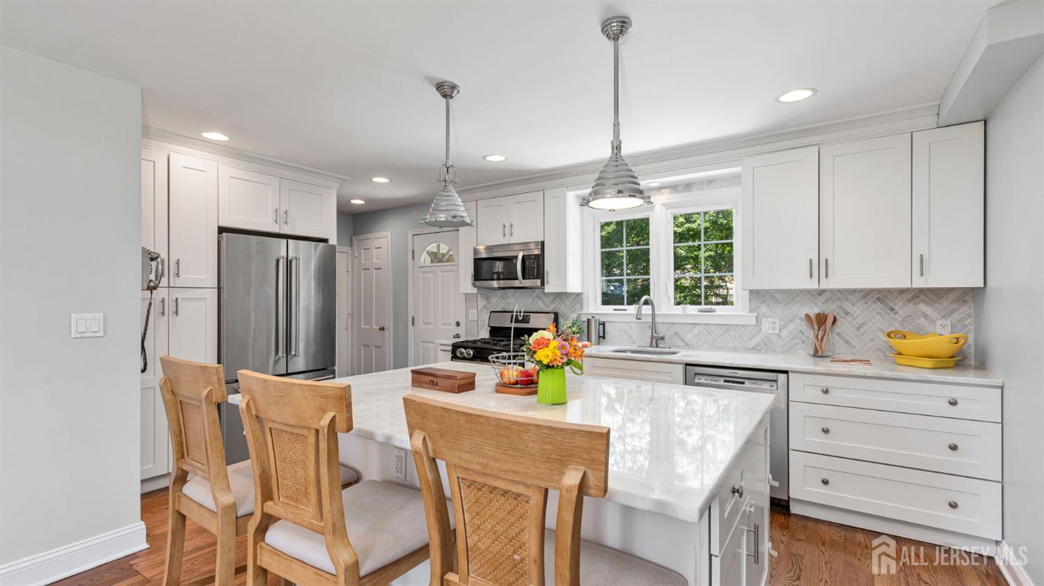 1085 Kenyon Avenue Plainfield, NJ 07060 - Photo 15 of 50 a kitchen with stainless steel appliances granite countertop a refrigerator a sink dishwasher a dining table and chairs with wooden floor