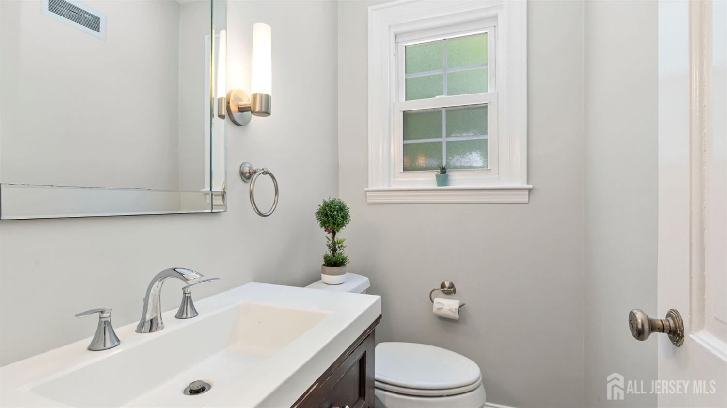 1085 Kenyon Avenue Plainfield, NJ 07060 - Photo 19 of 50 a bathroom with a sink a toilet and a mirror