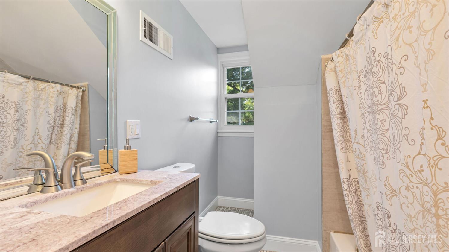 1085 Kenyon Avenue Plainfield, NJ 07060 - Photo 35 of 50 a bathroom with a granite countertop sink toilet a mirror and shower curtain