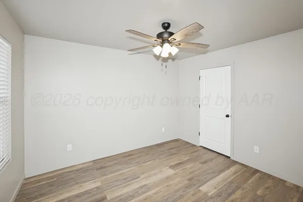 a view of a small space with wooden floor and a chandelier fan
