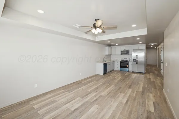 a view of empty room with wooden floor and ceiling fan