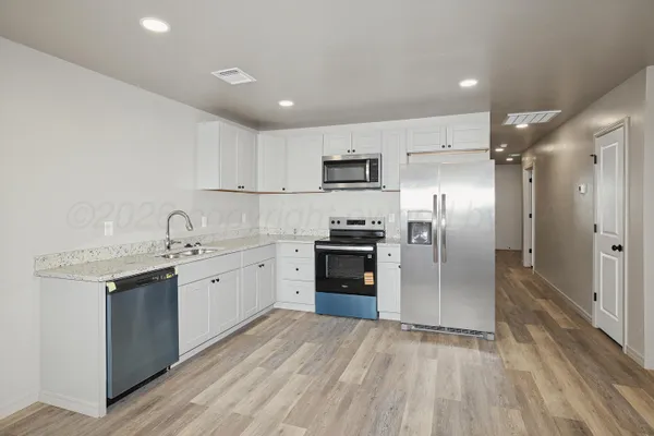 a kitchen with kitchen island a refrigerator sink and stove
