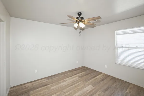 a view of a room with wooden floor and a ceiling fan