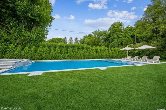 a view of yard with swimming pool and green space