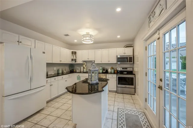 a kitchen with granite countertop a refrigerator stove top oven and sink
