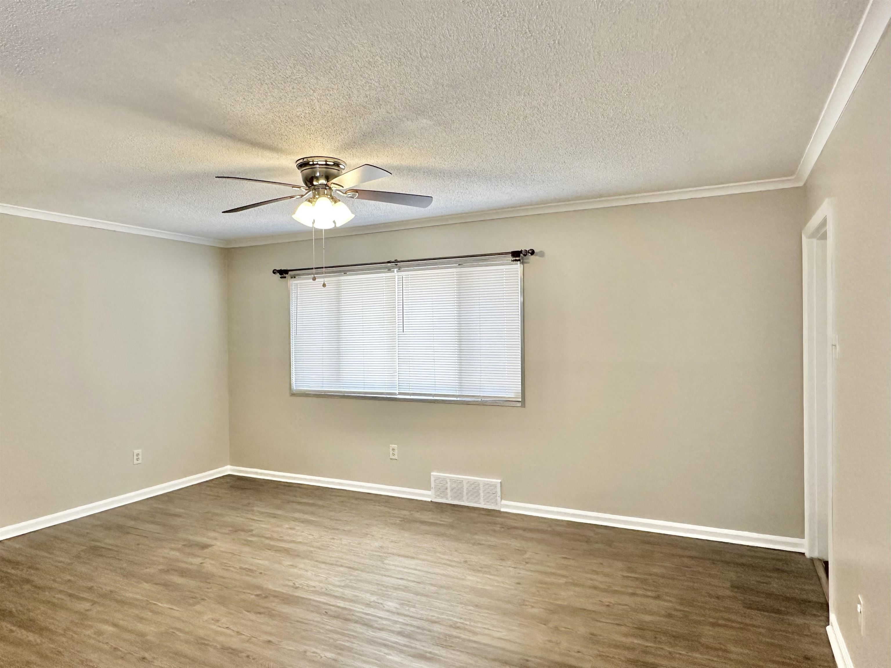141 North White Station Road Memphis, TN 38117 - Photo 10 of 24 a view of an empty room with window and wooden floor