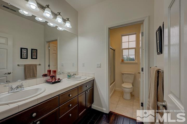 10520 Baton Court Reno, NV 89521 - Photo 27 of 38 a bathroom with a double vanity sink a toilet and a mirror