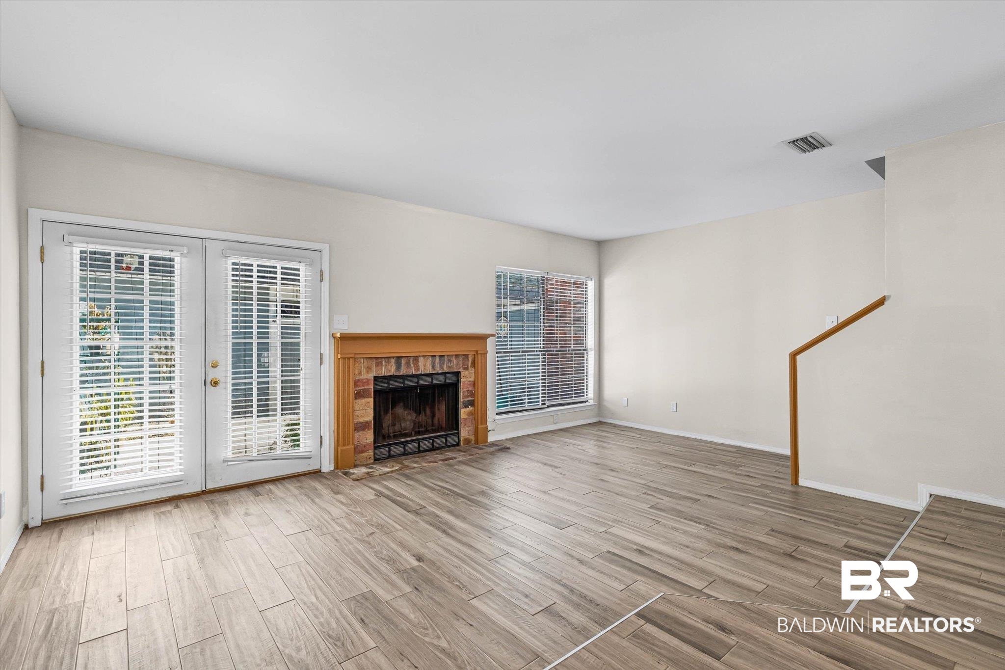 5900 Grelot Road, Unit 504 Mobile, AL 36609 - Photo 3 of 24 Unfurnished living room featuring wood finish floors and a fireplace