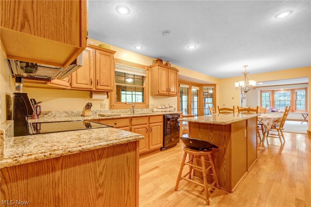 2645 Frost Road Mantua, OH 44255 - Photo 13 of 35 Kitchen with granite countertops island light hardwood flooring