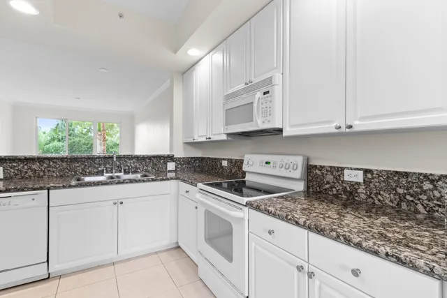 a kitchen with white cabinets and sink