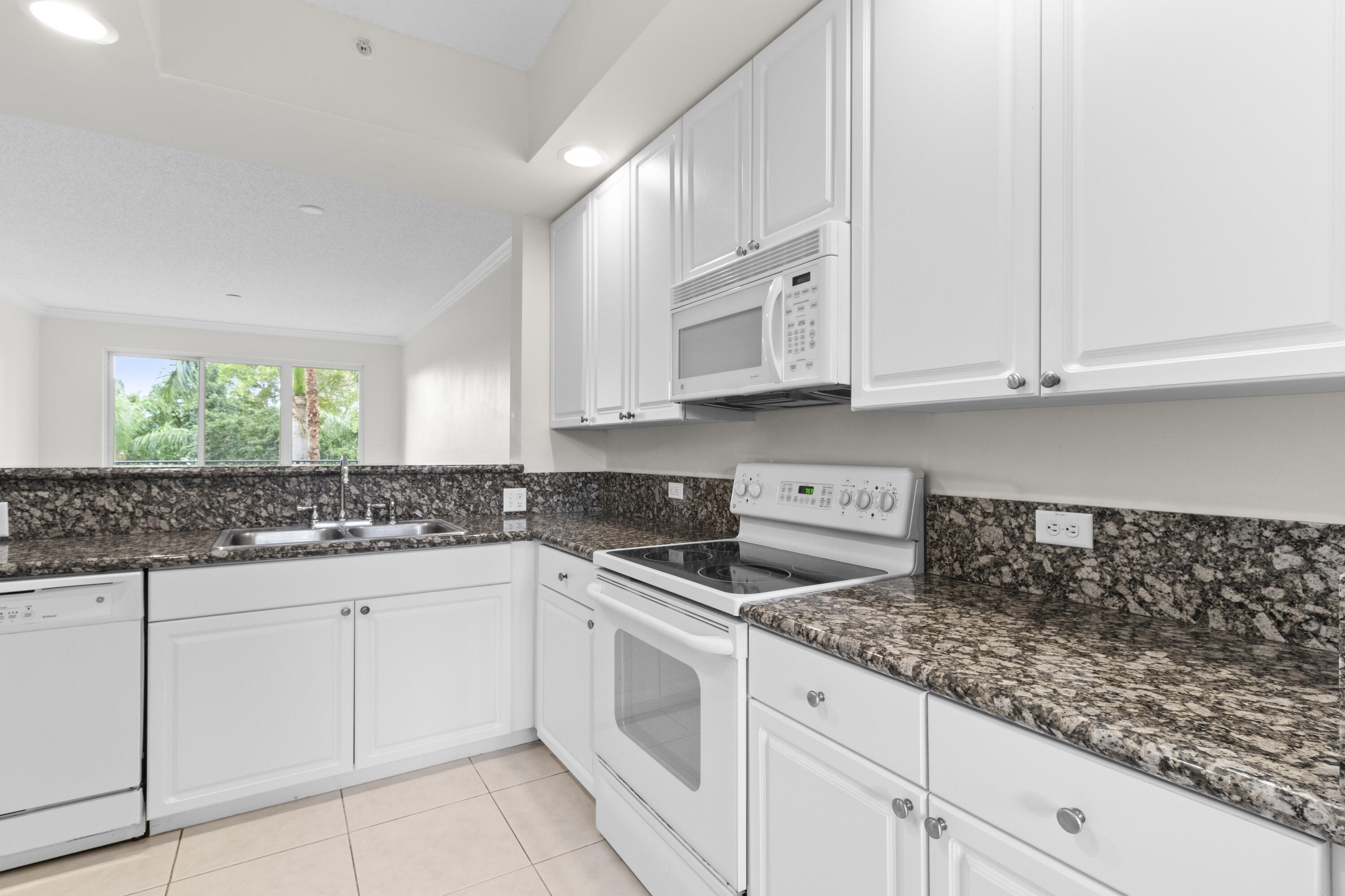 a kitchen with white cabinets and sink