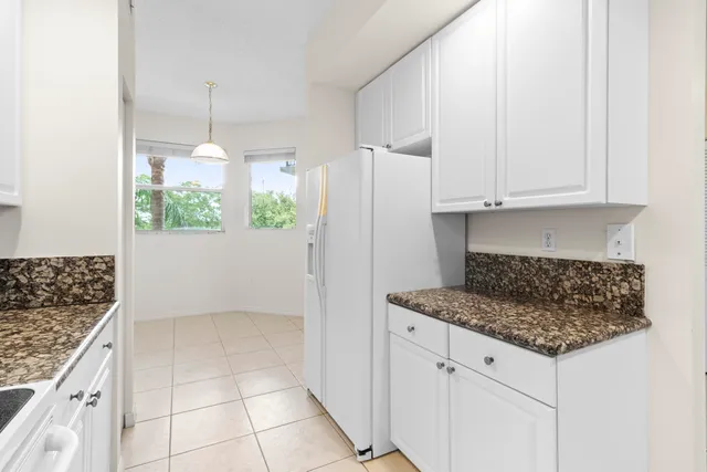 a kitchen with granite countertop white cabinets and stainless steel appliances