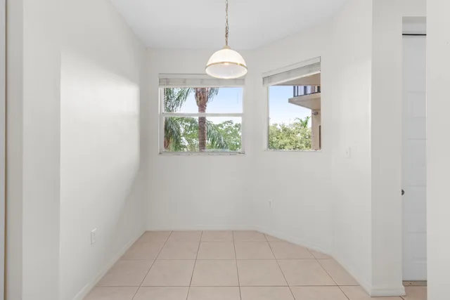 an empty room with windows and chandelier