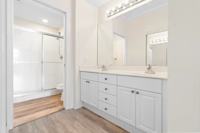 an empty room with wooden floor and fan