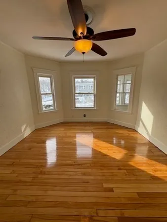 a view of empty room with window and ceiling fan
