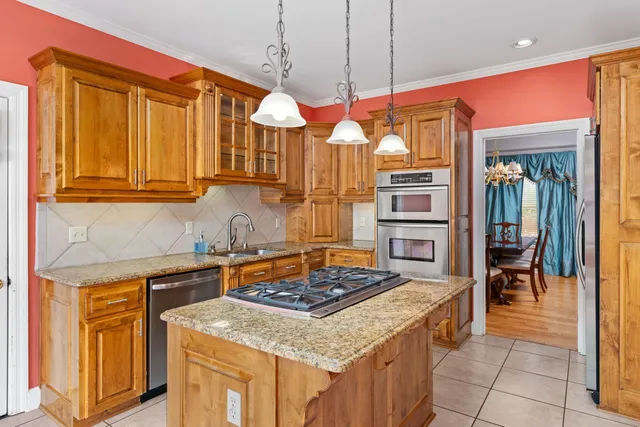 a kitchen with stainless steel appliances granite countertop a stove a sink and a microwave