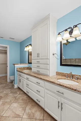 an empty room with wooden floor chandelier fan and windows