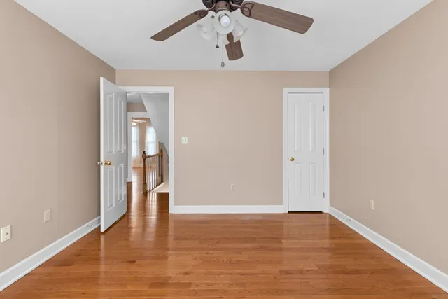 a view of a room with wooden floor and a ceiling fan