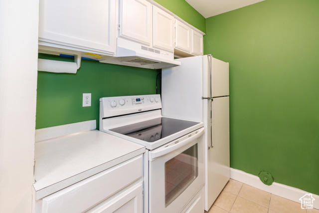 167 East 100 North, Unit B Logan, UT 84321 - Photo 7 of 18 Kitchen with white appliances, white cabinets, light tile patterned floors, under cabinet range hood, and light countertops