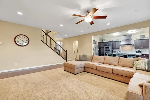 a living room with furniture kitchen view and a chandelier