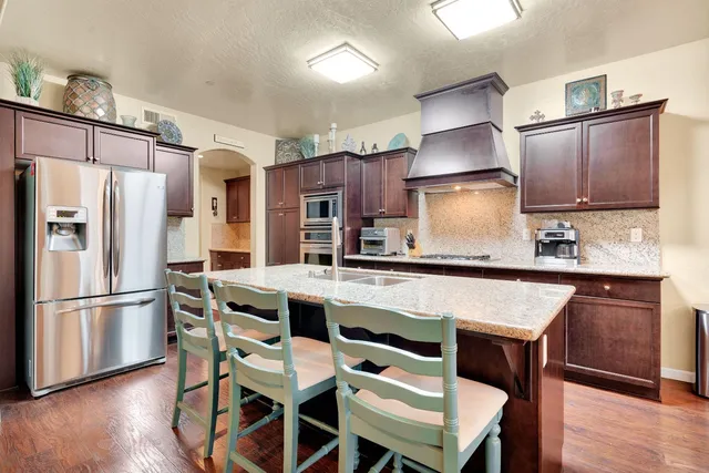 a kitchen with stainless steel appliances granite countertop a stove and a refrigerator