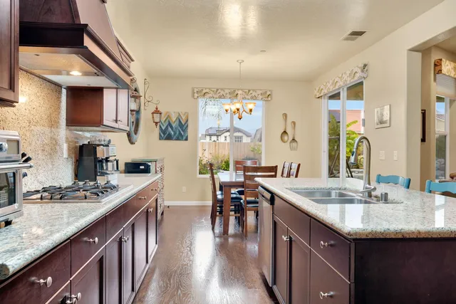a kitchen with stainless steel appliances granite countertop a sink stove and cabinets