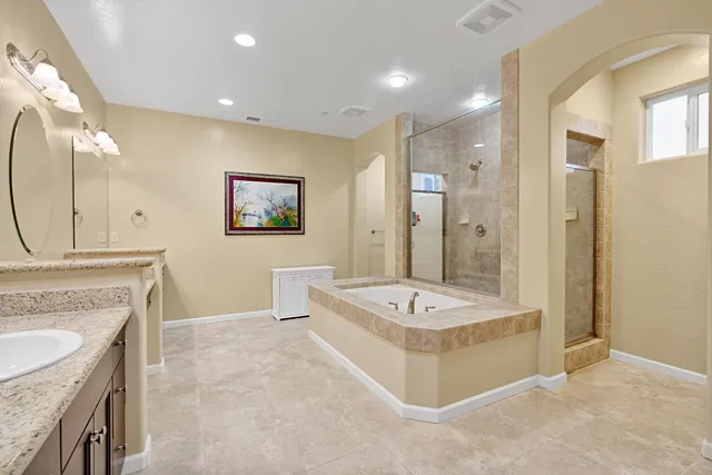 a spacious bathroom with a shower tub sink and mirror