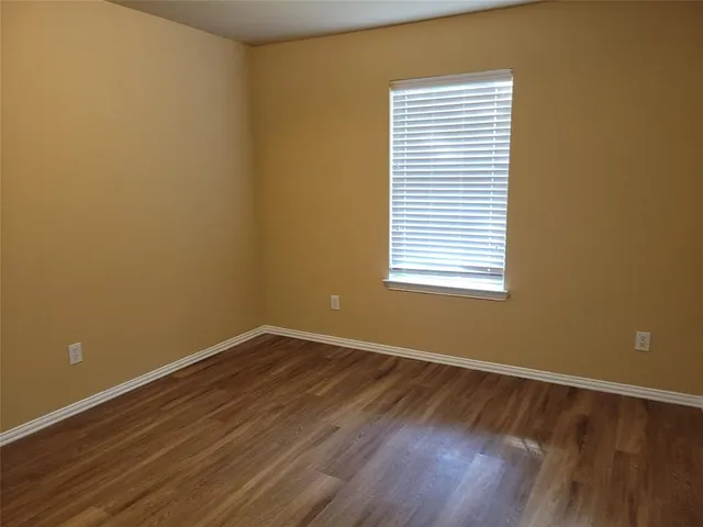 a view of a room with wooden floor and a window
