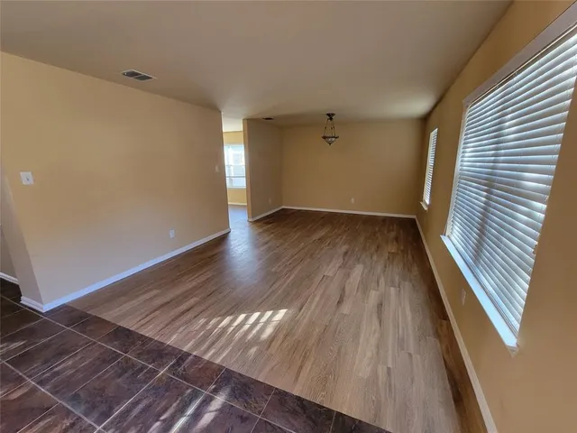 a view of wooden floor in a hall with a window