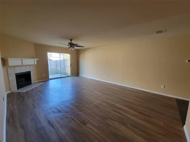 a view of a livingroom with wooden floor a fireplace and windows