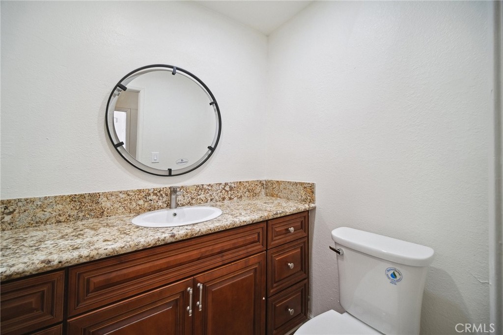 1926 Lucas Street, Unit 2 San Fernando, CA 91340 - Photo 17 of 35 a bathroom with a granite countertop toilet a sink and a mirror