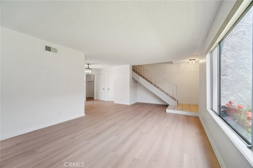 1926 Lucas Street, Unit 2 San Fernando, CA 91340 - Photo 5 of 35 a view of an empty room with wooden floor and a window