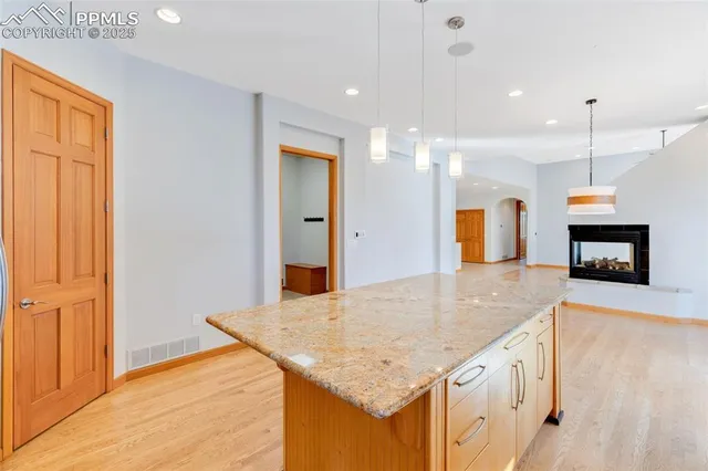 a kitchen with granite countertop kitchen island a sink appliances and a counter space