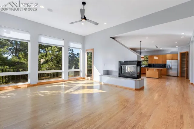 a view of a hall with wooden floor and a large window