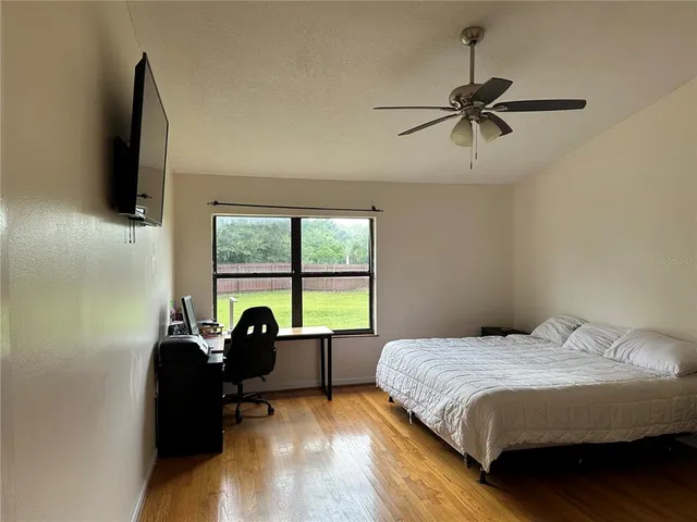 a bedroom with a bed and a flat tv screen on the dresser