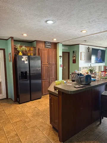 a kitchen with stainless steel appliances granite countertop a sink a refrigerator and a stove